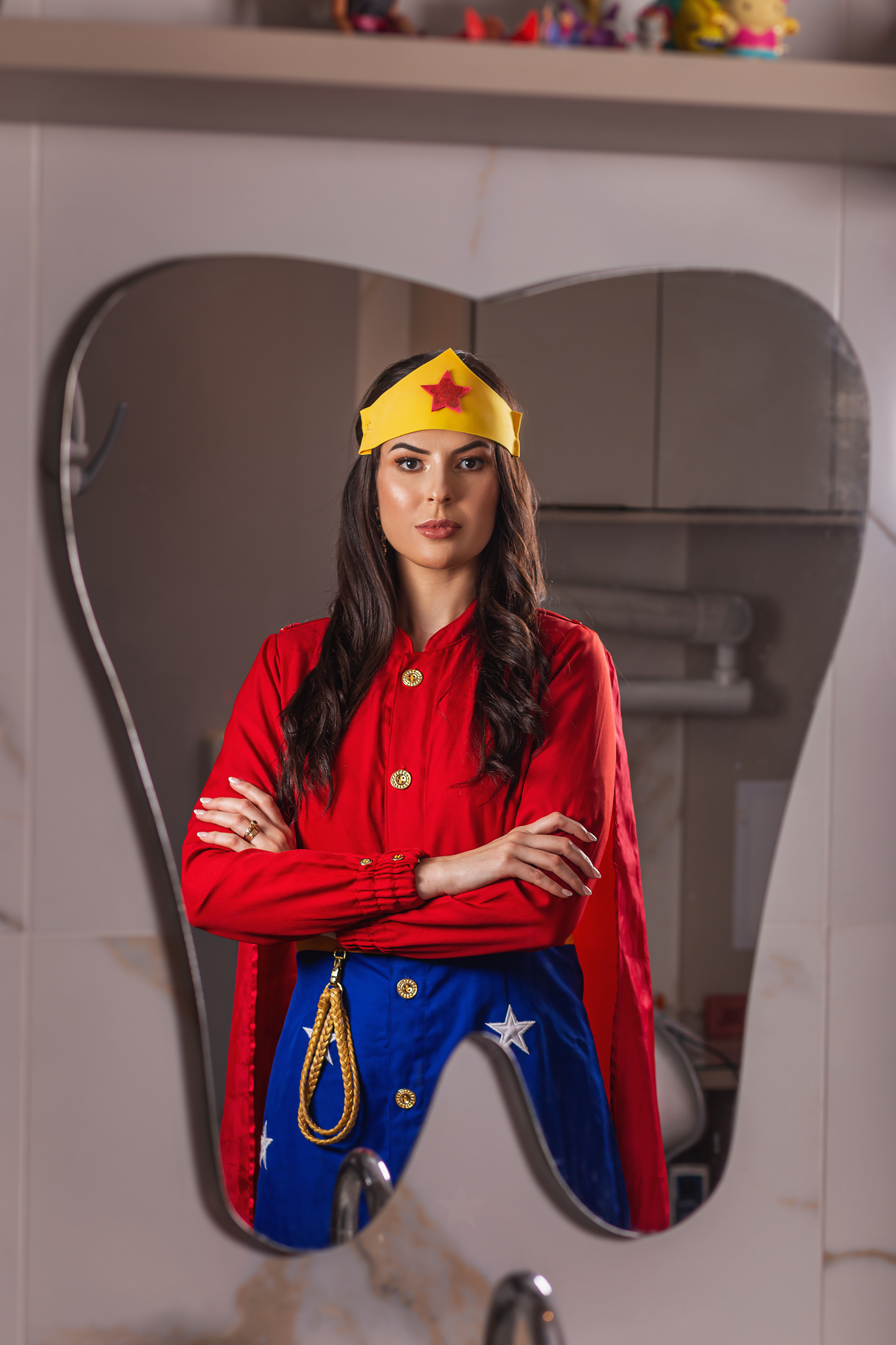 Dra. Natália fantasiada de Mulher Maravilha atendendo criança